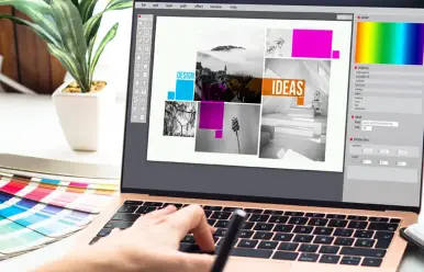 Webdesigner gestaltet am Laptop ein modernes Webseiten-Layout mit frischen Design-Ideen und klaren Strukturen.